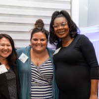 3 women pose together in the Alumni House